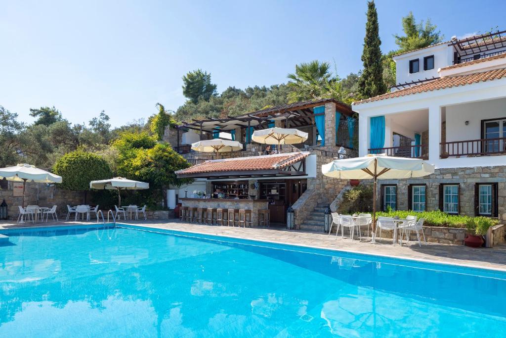 un hotel con piscina frente a un edificio en Aegean Suites en Megali Ammos