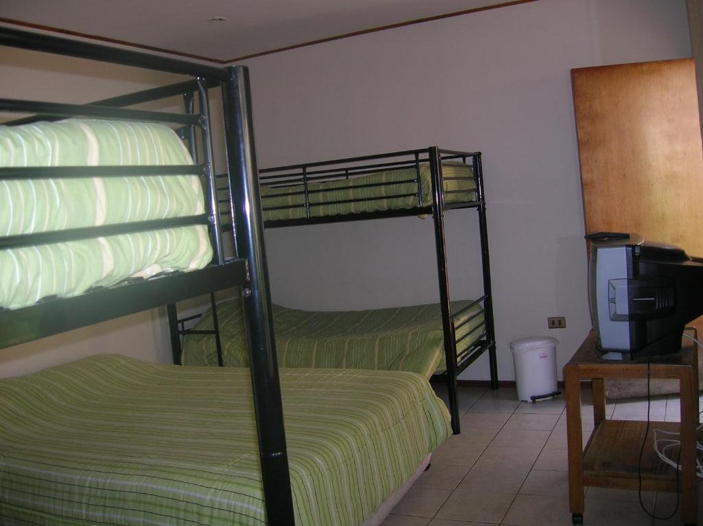 een slaapkamer met 2 stapelbedden en een televisie bij Iquique Beachfront in Iquique