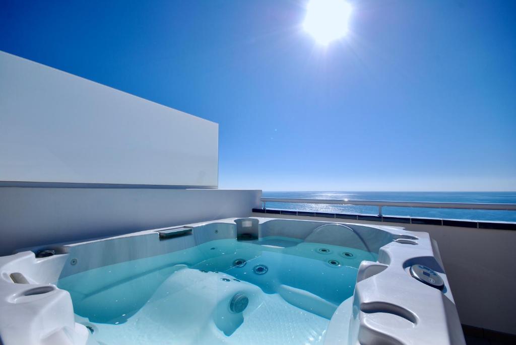a bath tub in a room with a blue light at Sea Lovers Jacuzzi Fuerteventura in Gran Tarajal
