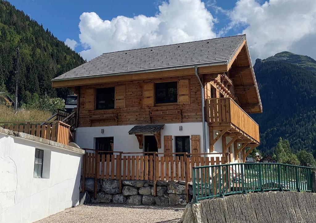 モルジヌにあるJust Morzine - Chalet Lunaの山の上にバルコニー付きの木造家屋