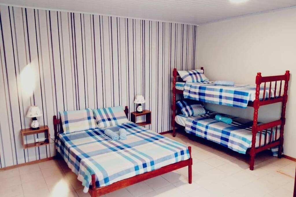 a bedroom with two twin beds and a chair at Solar de Paz 3 - ubicado en pleno Centro in Rivera