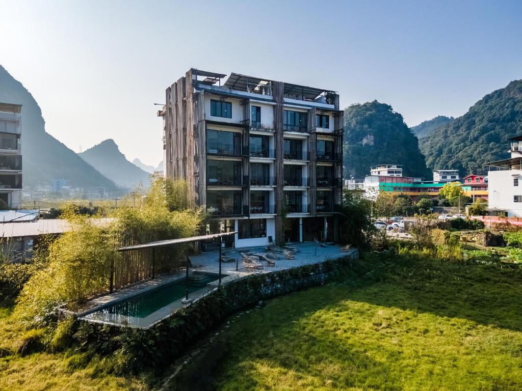 a building in a city with mountains in the background at Yangshuo Sudder Street Guesthouse in Yangshuo