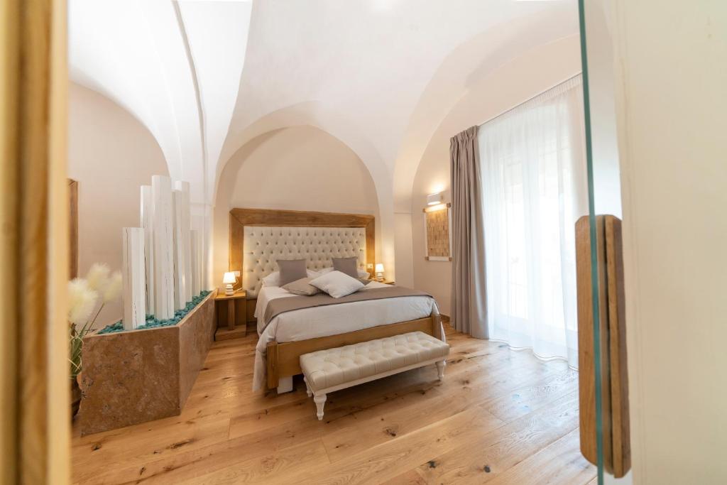 a bedroom with a bed and a large window at IL Borgo Relais in Gravina in Puglia