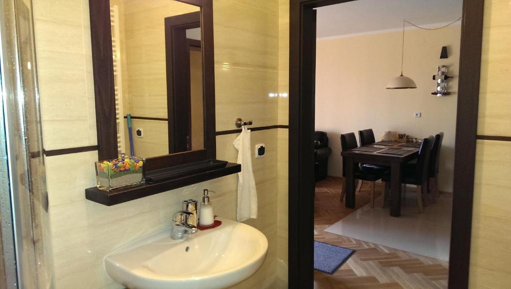 a bathroom with a sink and a table with a dining room at Apartament Urocza in Szklarska Poręba
