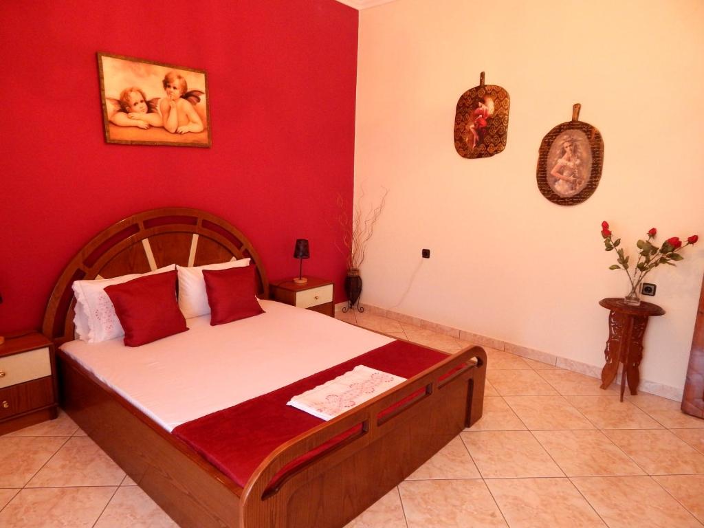 a bedroom with a large bed with red walls at Montagna e mare in Kallirakhi