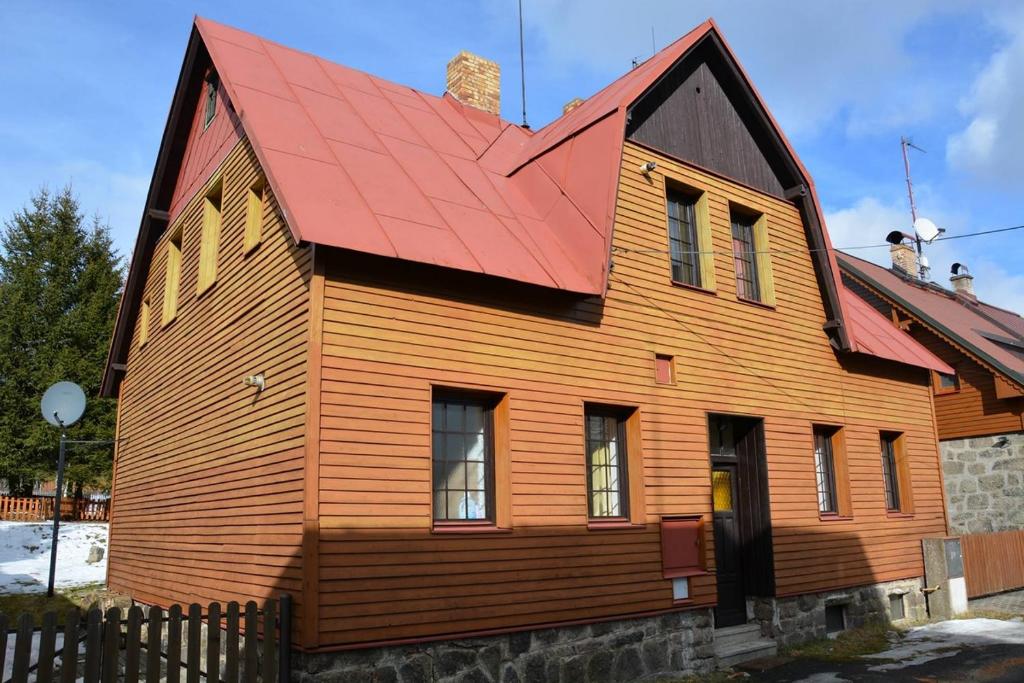 a large wooden house with a red roof at Holiday Home Abertamy in Abertamy