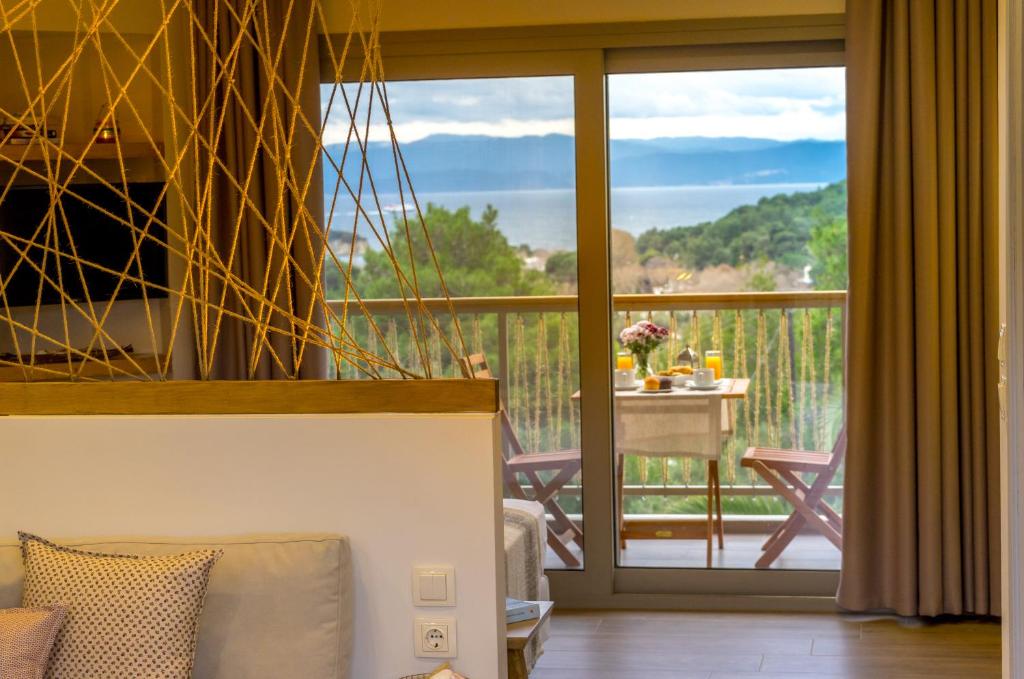 a living room with a view of a balcony at Forest Resort Suites Skiathos in Troulos