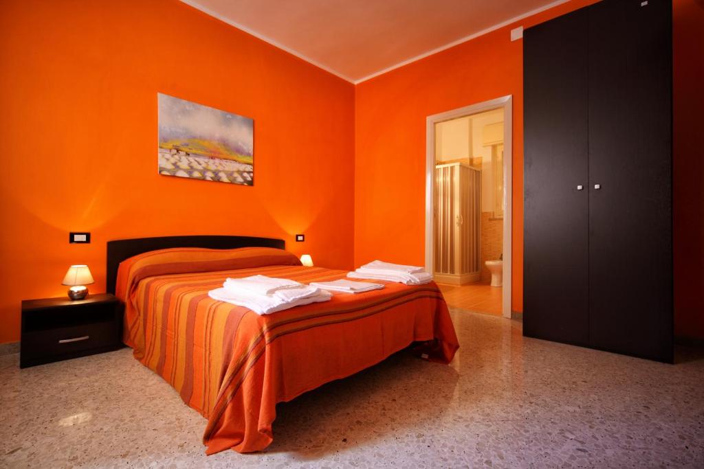 a orange bedroom with a bed with orange walls at B&B Dimora Del Principe in Trapani