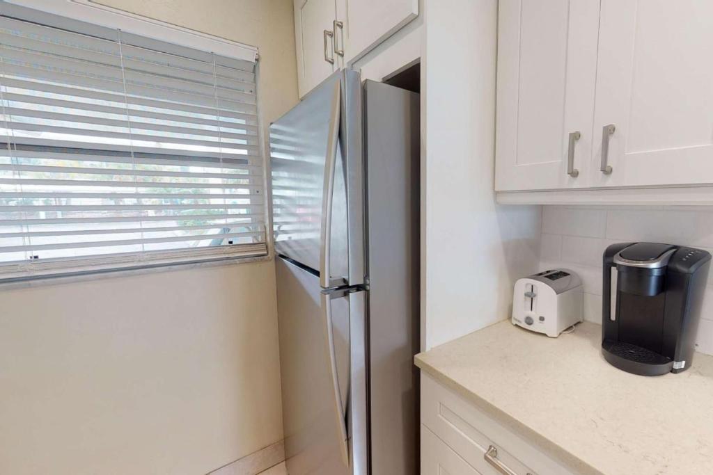 eine Küche mit einem Kühlschrank aus Edelstahl und weißen Schränken in der Unterkunft Jamaica Royale 2BR TownHome in Siesta Key