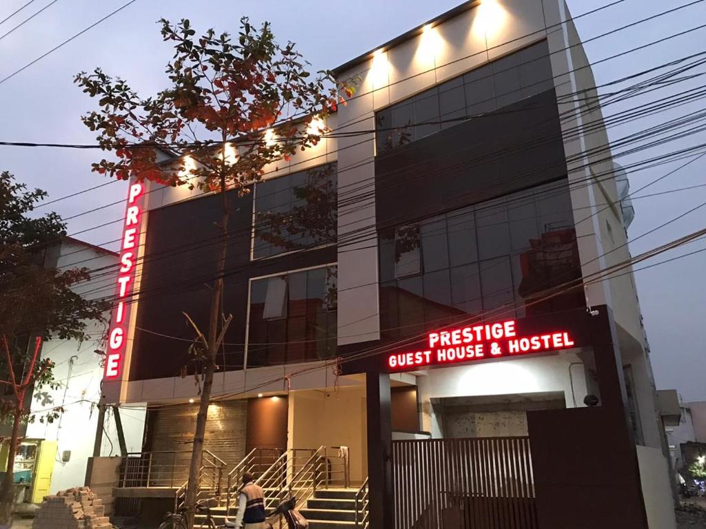 un edificio con un cartello che legge prestige guest house e musica di Prestige Guest House & Hostel a Bilaspur