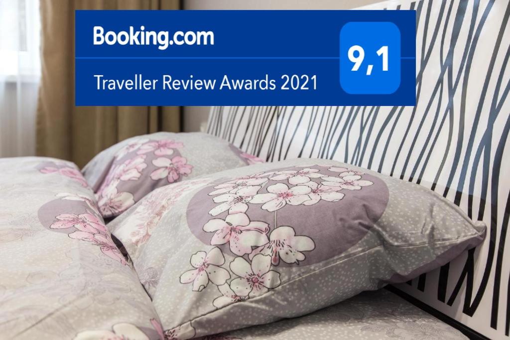 Un par de almohadas en una cama con un cartel azul que dice revisión de viajes en Apartments near Dolphinarium, en Truskavets