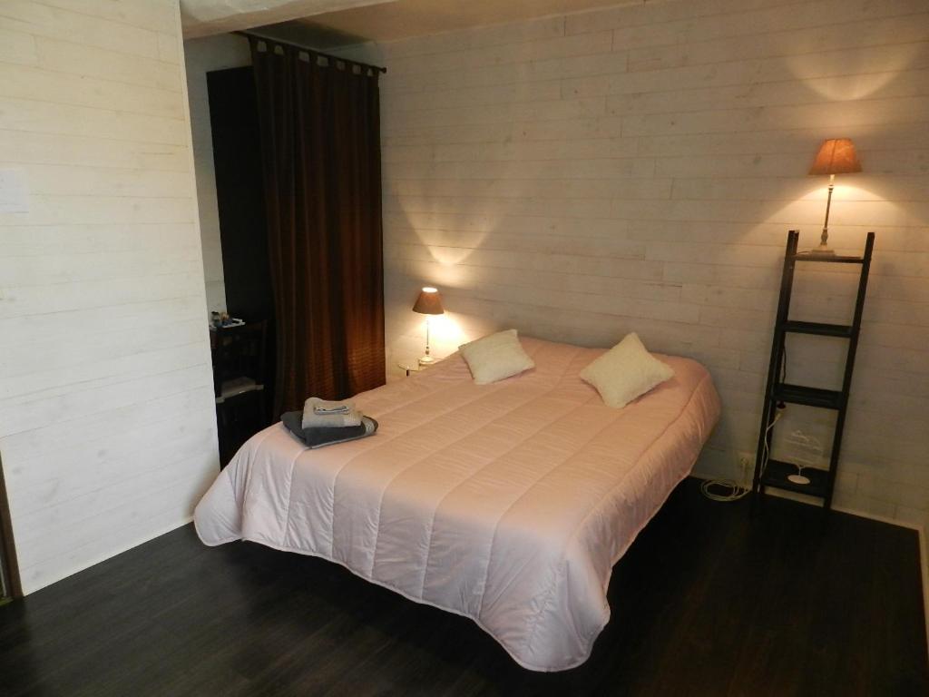 una camera con un letto bianco con due cuscini di les chambres du parc a Dammarie-sur-Saulx