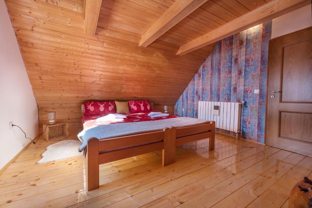 a bed in a room with a wooden ceiling at Vila Carmen kuća za odmor sa wellnessom,Sunger in Mrkopalj