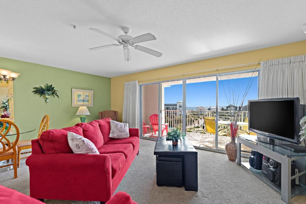 a living room with a red couch and a flat screen tv at Amalfi Coast B420 in Destin