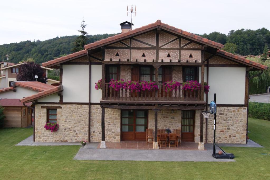 una casa con un balcón con flores. en CASA RURAL BAKUBITXI en Murguía