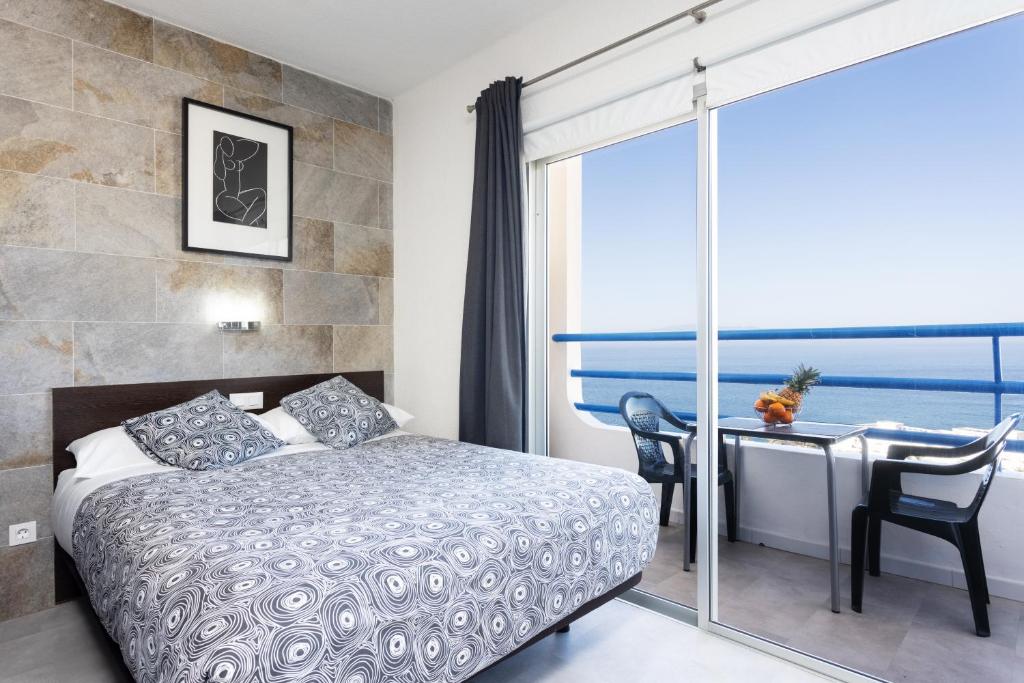 アデへにあるParaiso Del Sur Playaのベッドルーム1室(ベッド1台、海の景色を望むデスク付)