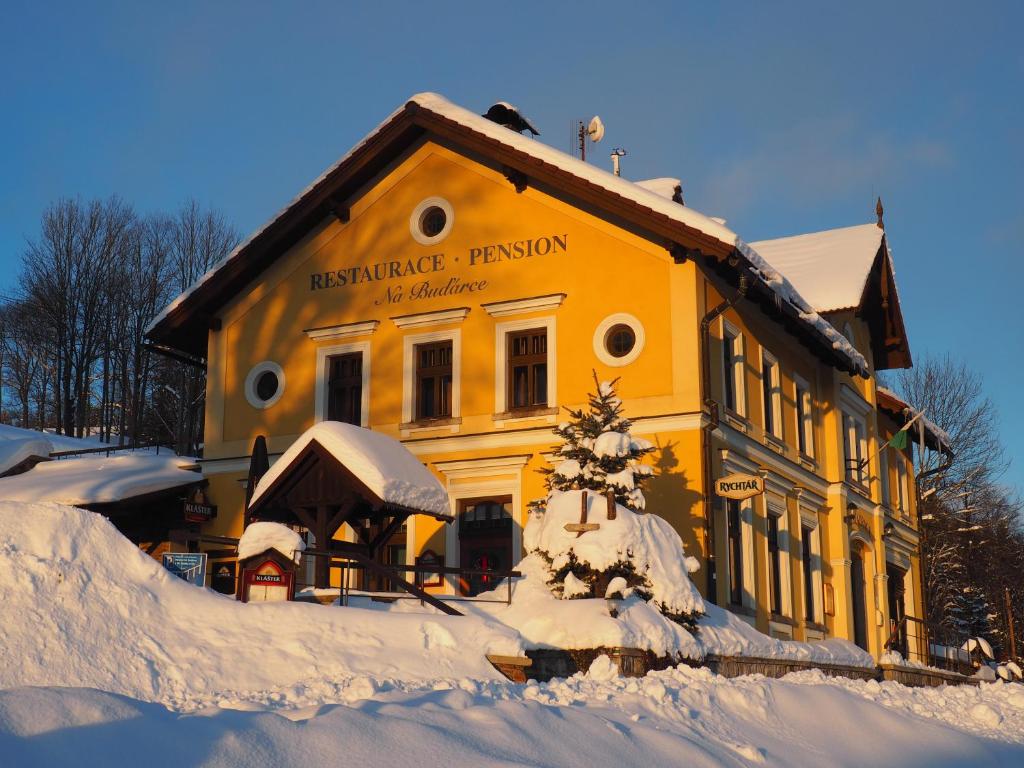 un edificio amarillo con nieve delante en Na Buďárce, en Paseky nad Jizerou