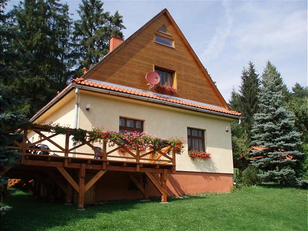 une maison avec un toit en gambrel et un balcon dans l'établissement Chalet Horáren, à Smižany