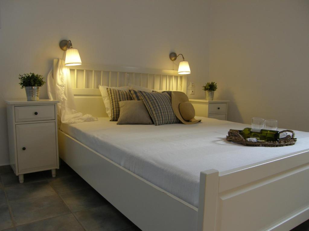 a large white bed in a bedroom with two lights at Chez Semiramis The Sun Touch House for 8 persons 5'min from the beach in Rámos