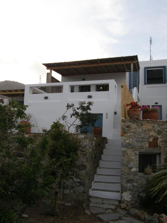 a white house with a stone wall and stairs at Chez Semiramis The Sun Touch House for 8 persons 5'min from the beach in Rámos