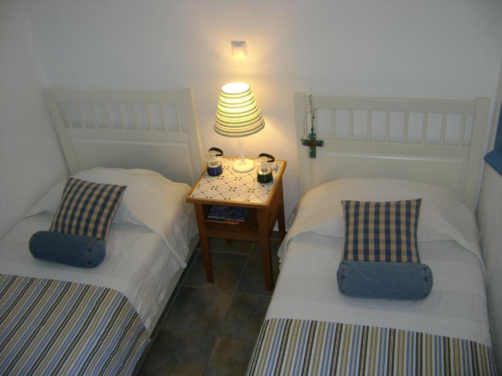 two beds in a room with a table and a lamp at Chez Semiramis The Sun Touch House for 8 persons 5'min from the beach in Rámos