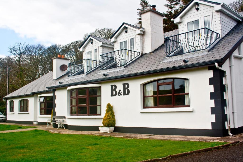 a white house with a letter b on it at Anchor House Accommodation in Newport