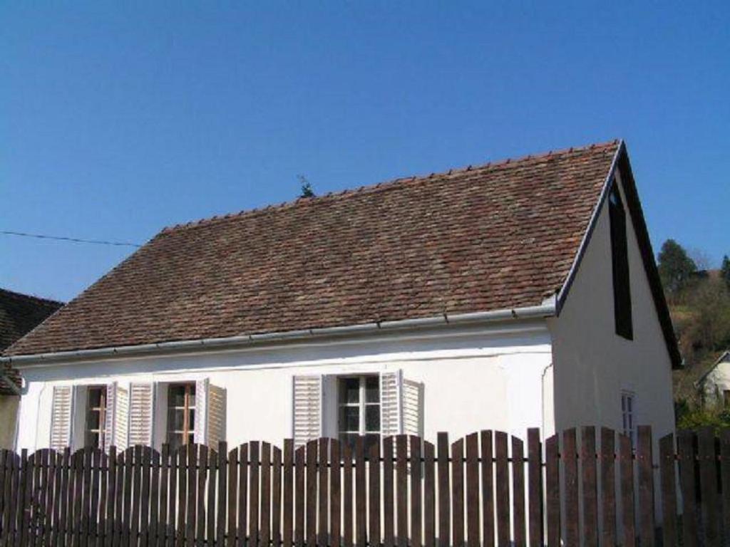 a white house with a brown roof and a fence at Holiday home- Galóca in Helesfa