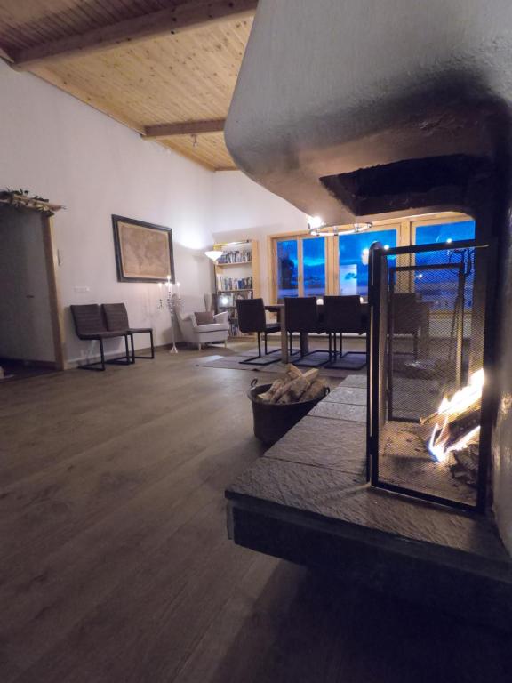 a living room with a fireplace and a piano at Berggatan Villa - Lägenhet 1 in Funäsdalen