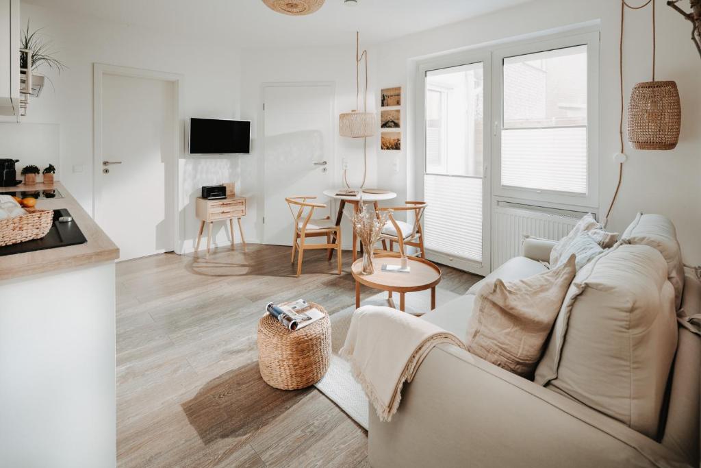 ein Wohnzimmer mit einem Sofa und einem Tisch in der Unterkunft Haus Salz & Sand Whg Sand in Norderney