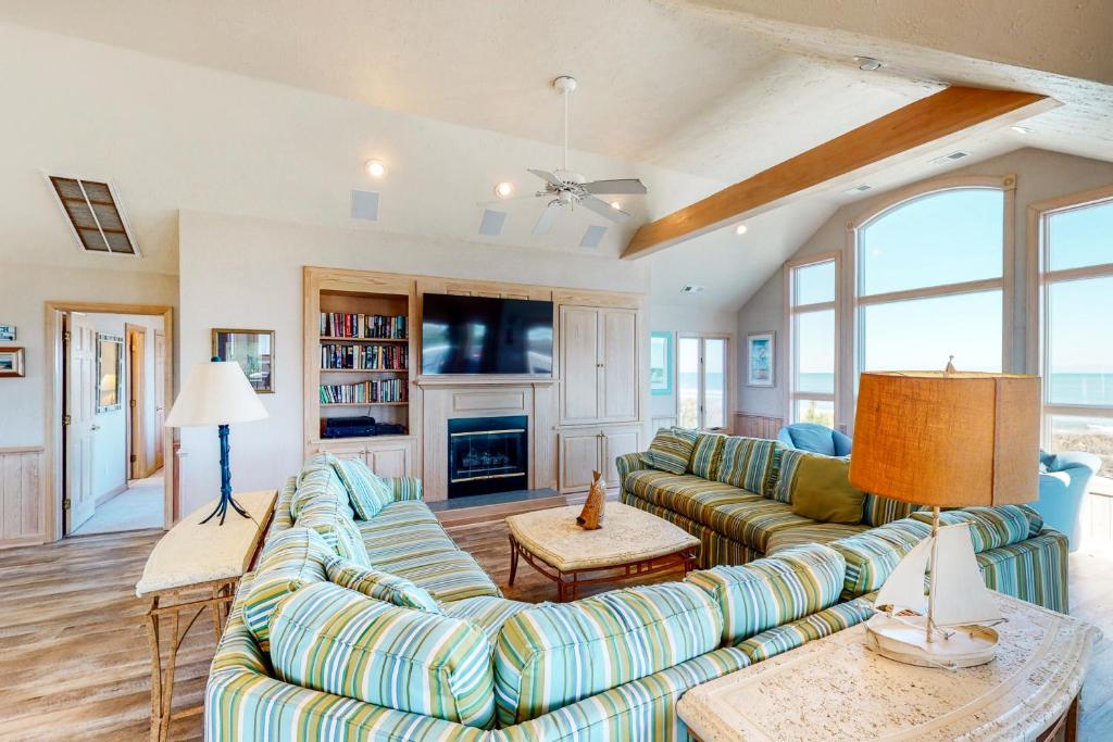 a living room with two couches and a fireplace at Sand Goodies PI128 in Corolla