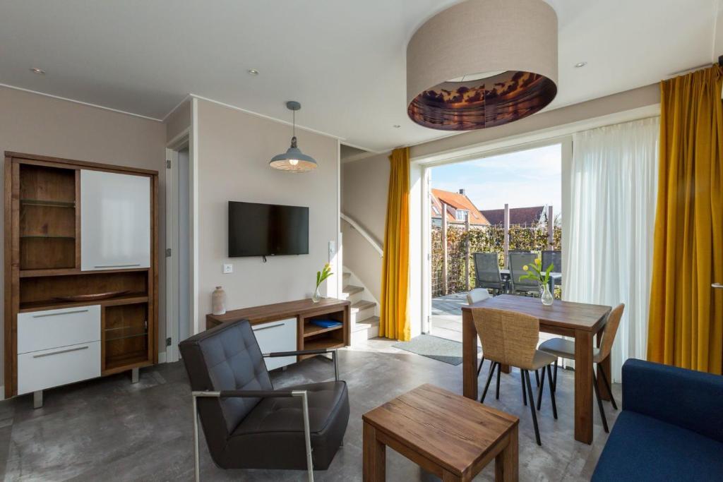 ein Wohnzimmer mit einem Tisch und einem Esszimmer in der Unterkunft Apartment - Noordweg 56a Oostkapelle Comfort 3 Personen in Oostkapelle