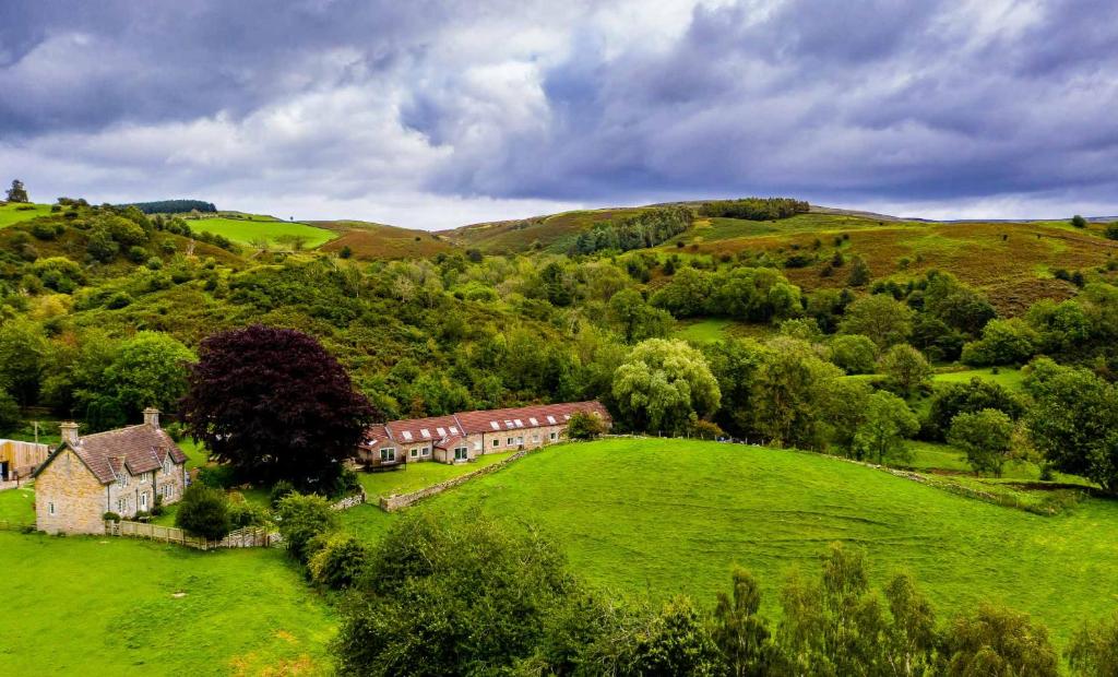 an aerial view of a house in a green field at Long Byres Holiday Cottages in Brampton