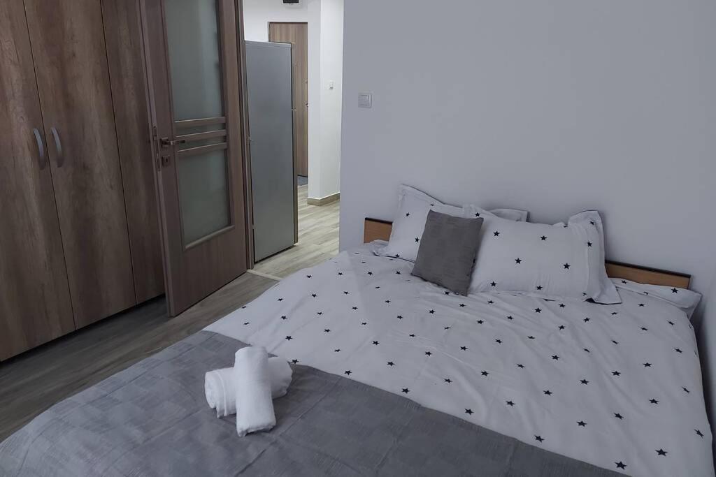 a bedroom with a white bed with black and white pillows at Hidden Apartment in Miercurea-Ciuc