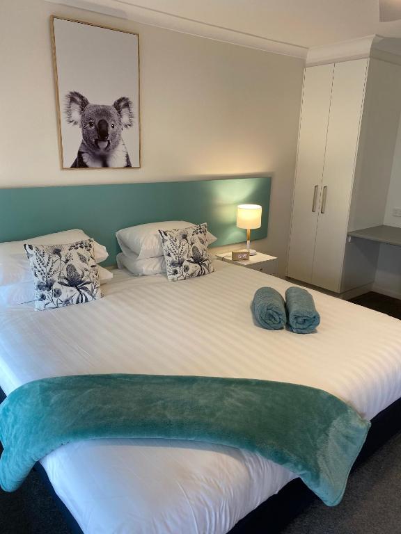 a bedroom with a large bed with a teddy bear on the wall at Botanic City Apartments in Warrnambool