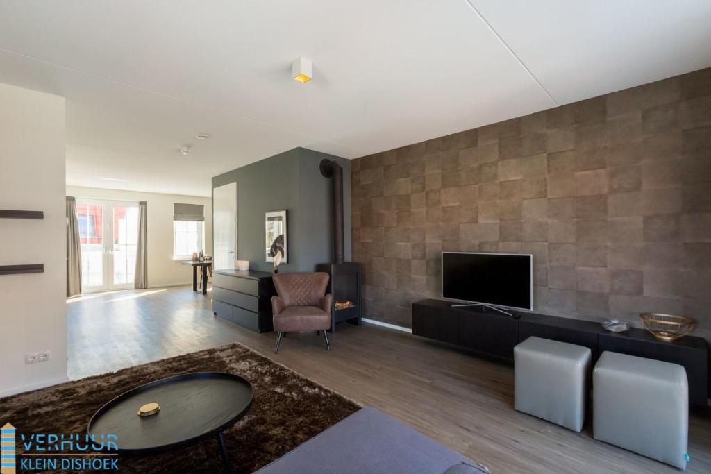 a living room with a couch and a tv at Appartement - Kaapduinseweg 13 Dishoek 13D Luxe 6 personen in Dishoek