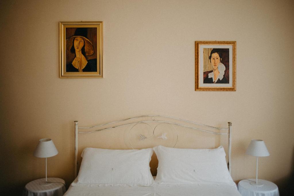 a bedroom with a bed with two pictures on the wall at Piazza Argento in Lecce