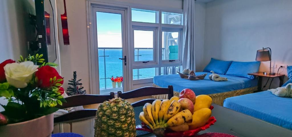 a living room with a table with a bowl of fruit at OceanFront at Arterra, fast WiFi, NFlix, kitchen -C in Mactan