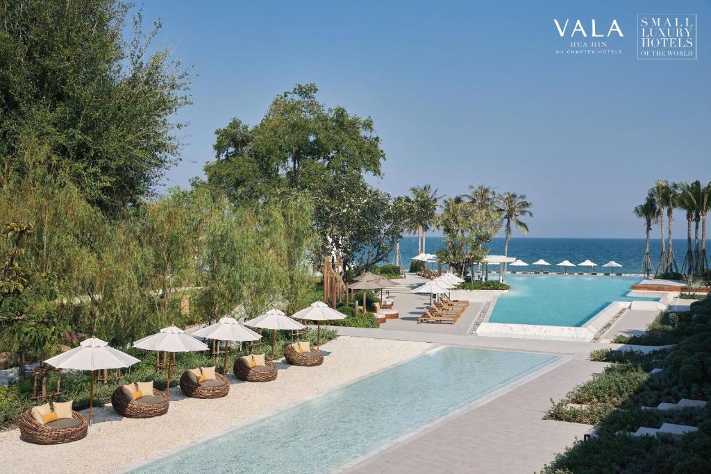 um resort com piscina, cadeiras e guarda-sóis em VALA Hua Hin - Nu Chapter Hotels em Cha Am