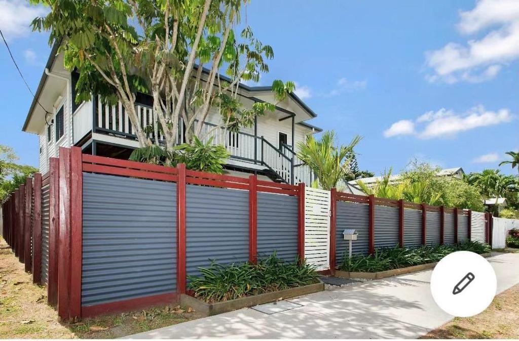 a fence with a garage door in front of a house at Martyn st house in Cairns