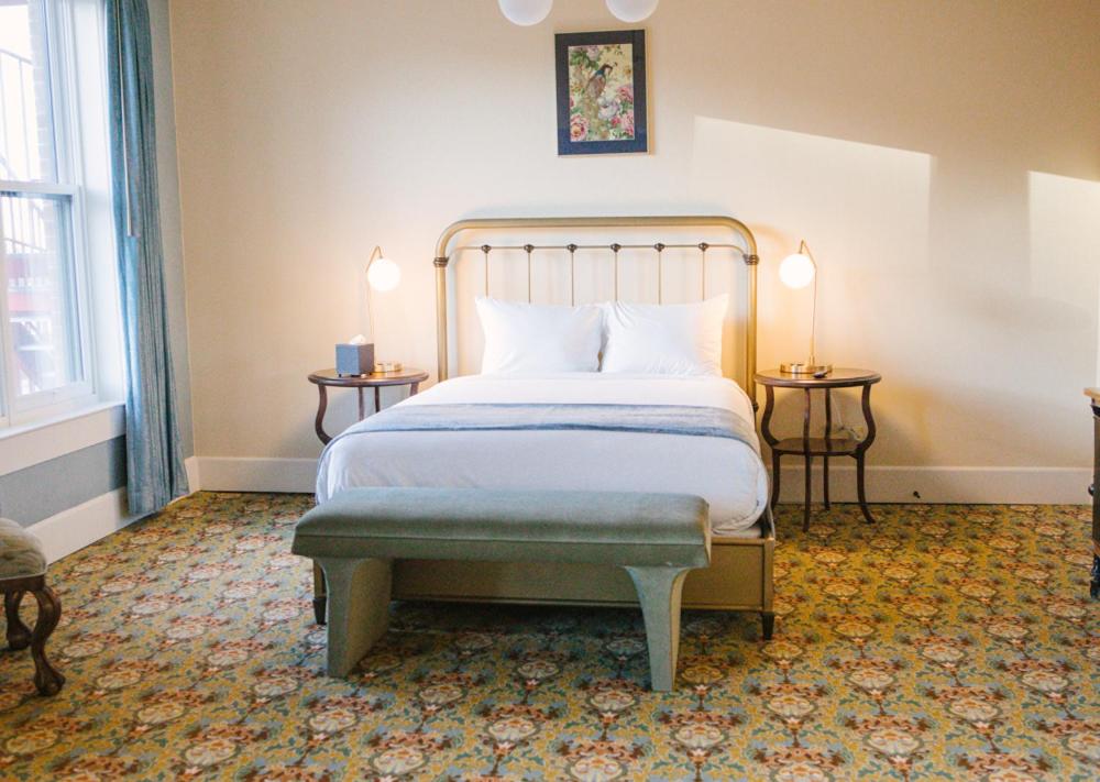 a bedroom with a bed and two tables with lamps at Belvada Hotel in Tonopah