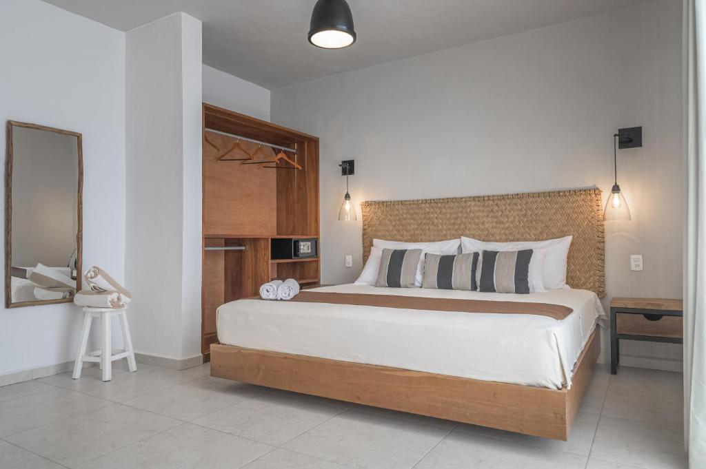 a bedroom with a bed and a dresser at Agam Hotel in Bacalar