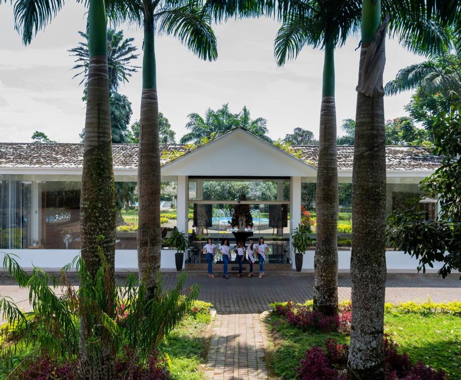 a group of children standing in front of a building with palm trees at Hotel Zaracay in Santo Domingo de los Colorados