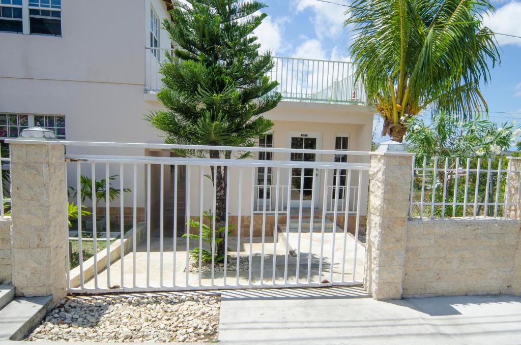 a gate with a palm tree in front of a building at Caribbean Inn and Suites in Saint Johnʼs