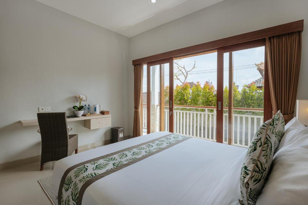 a bedroom with a large bed and a balcony at Nudel Canggu By Hospitality Bali in Canggu
