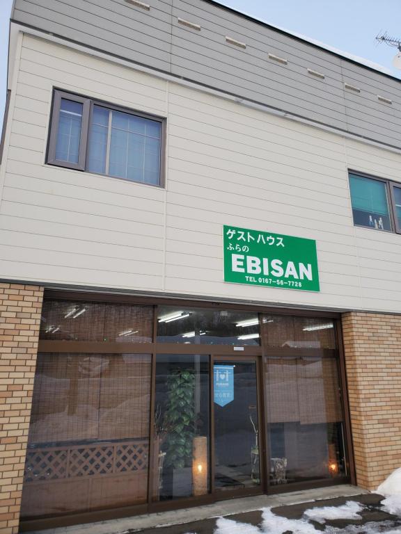 un edificio con un letrero para un restaurante asiático en Guest House EBISAN en Furano