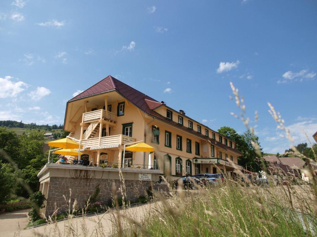 a yellow building with yellow umbrellas in front of it at Grüner Baum Naturparkhotel & Schwarzwald-Restaurant in Todtnau
