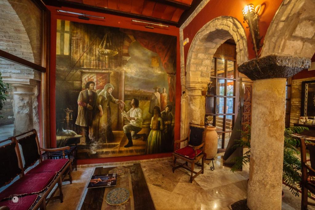 a living room with a large painting on the wall at Hotel Posada de Vallina by MiRa in Córdoba