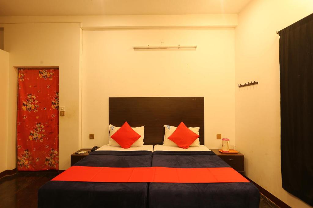 a bedroom with a bed with orange pillows at Le Apex Inn in Auroville
