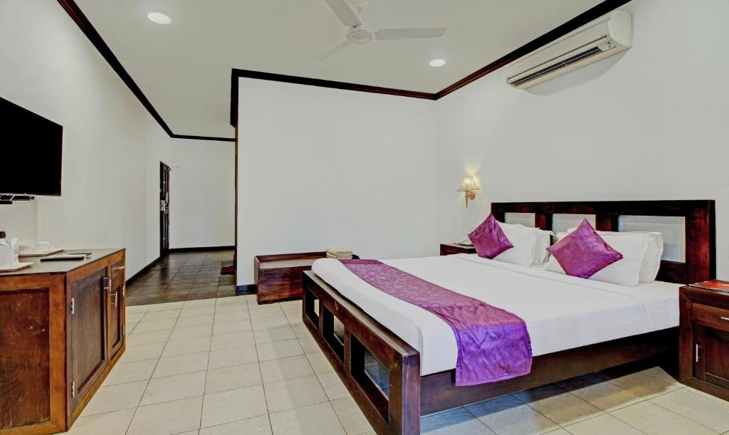 a bedroom with a large bed and a television at Treebo Premium Travancore Palace Cherthala in Alleppey
