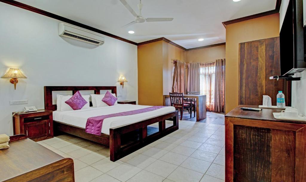 AlleppeyTreebo Premium Travancore Palace Cherthala的带一张大床和一张桌子的卧室